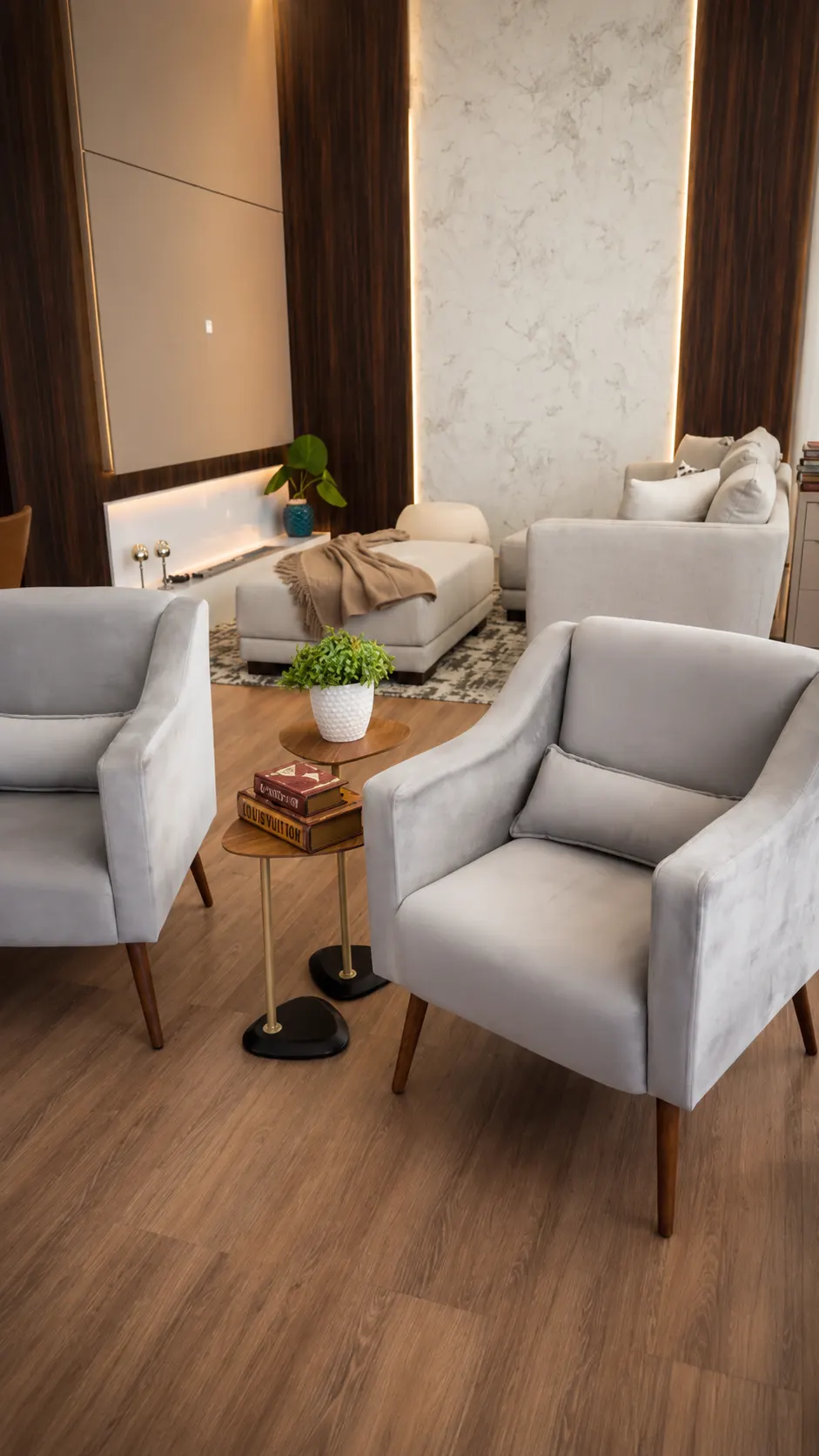 Poltronas cinza em veludo com mesas laterais em madeira e painel iluminado