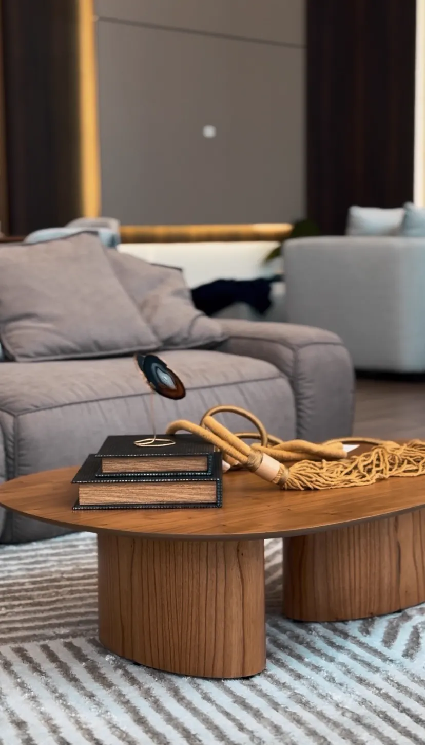 Detalhe de mesa de centro em madeira com objetos de decoração em living contemporâneo